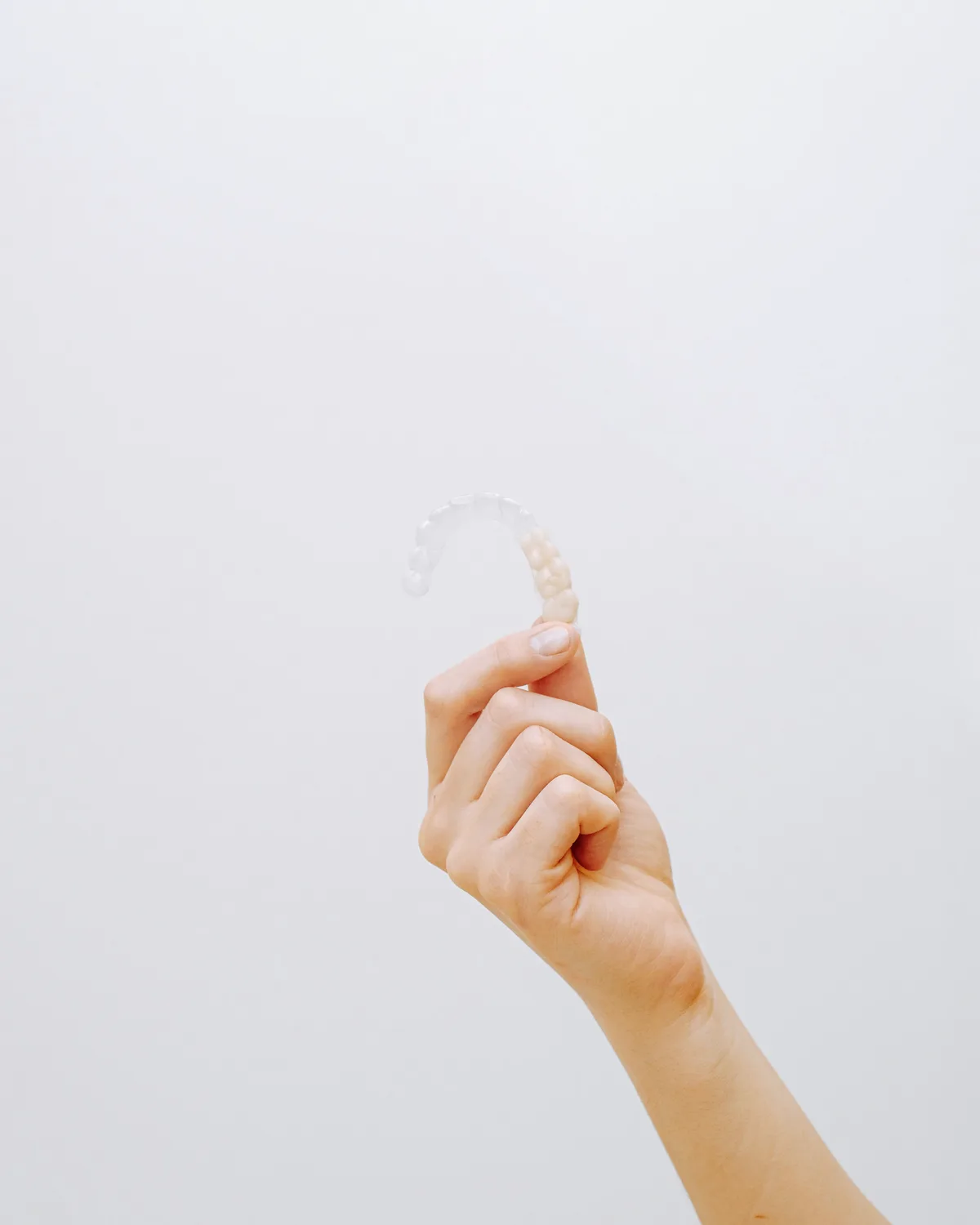 Férula de ortodoncia invisible sostenida en la mano